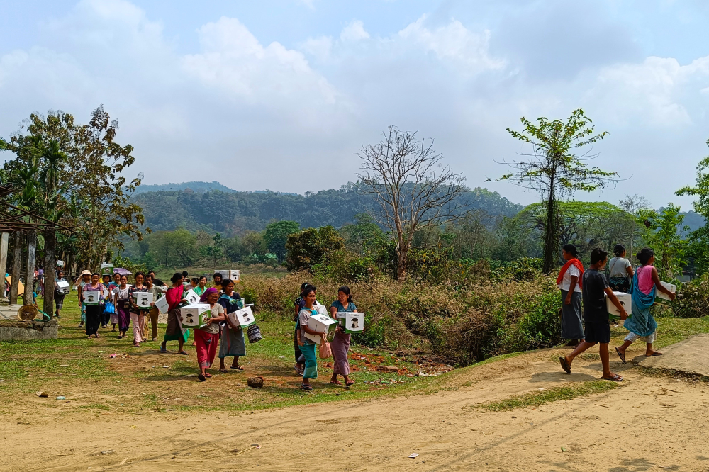 Villagers carrying clean cookstoves to their households