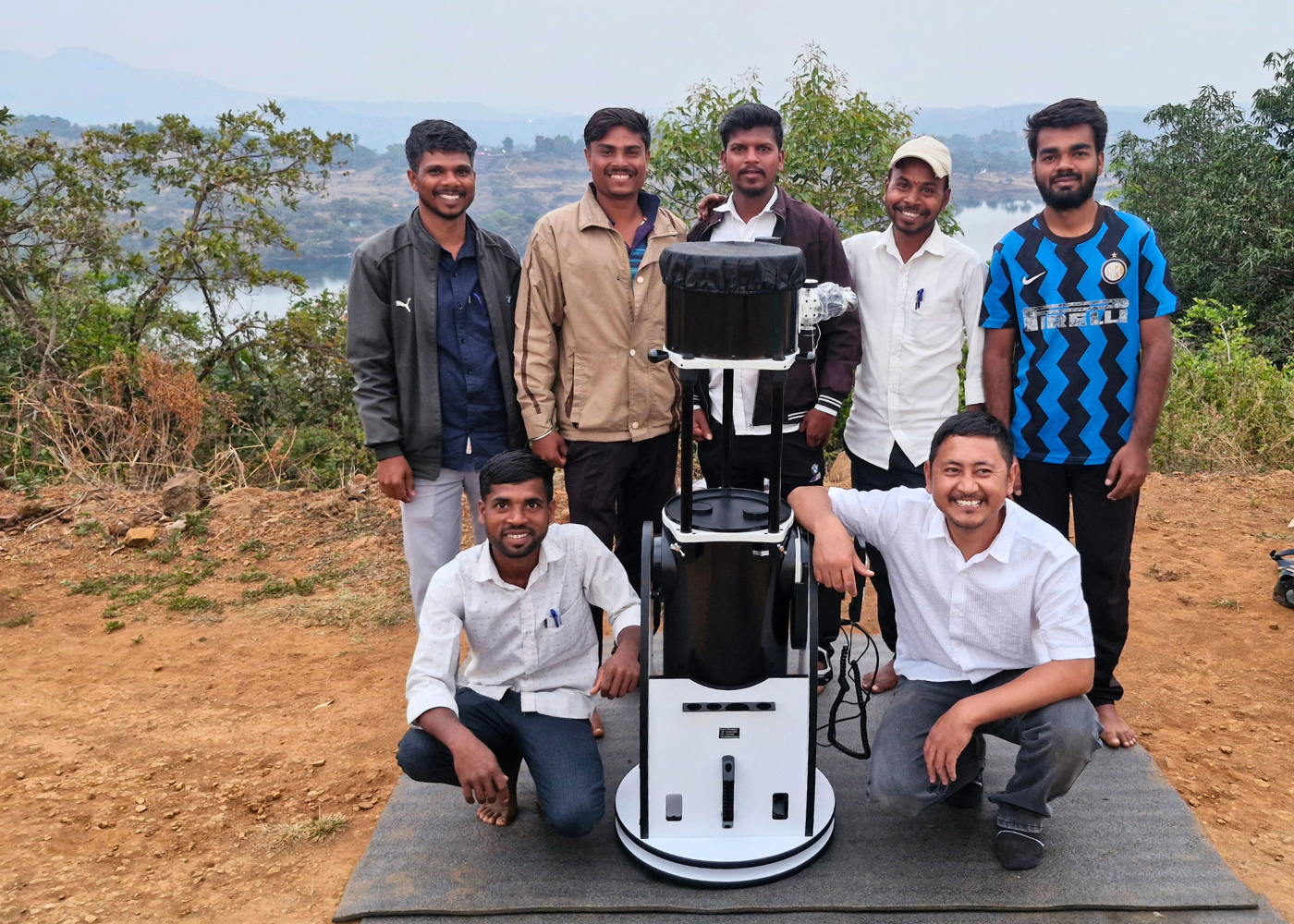 Participants and trainer proudly pose with the telescope after training